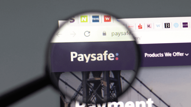Magnifying glass zooming in on Paysafe website