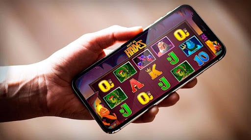 a picture of someone holding a iphone showing online casino slot games